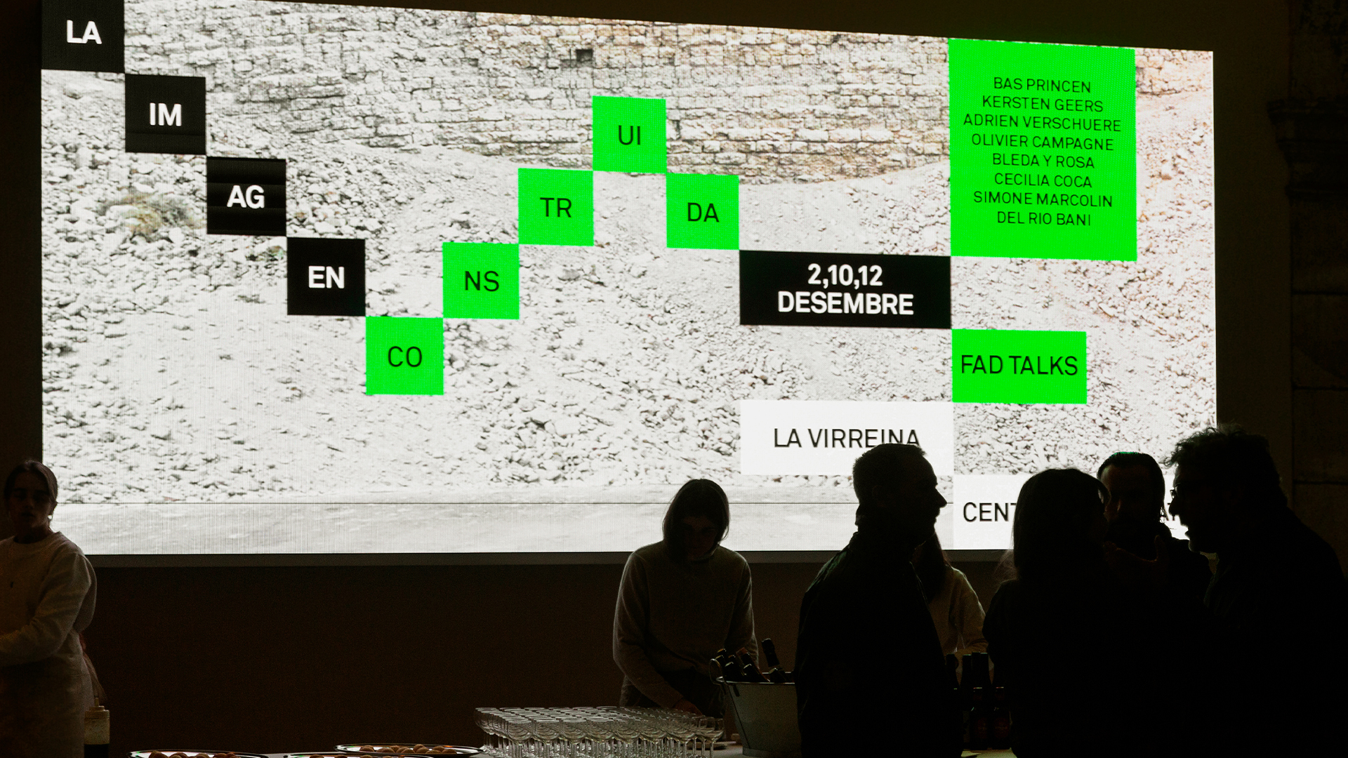 Exposici&oacute;n de la campa&ntilde;a de La Imagen Construida en La Virreina Centre de la Imatge, donde se muestran proyectadas las piezas gr&aacute;ficas en digital, mientras una multitud de gente observa la campa&ntilde;a gr&aacute;fica realizada por Esiete Studio, en un sistema reticular que genera composiciones din&aacute;micas, donde palabras e im&aacute;genes se construyen y deconstruyen en cuadrados negros y verdes.